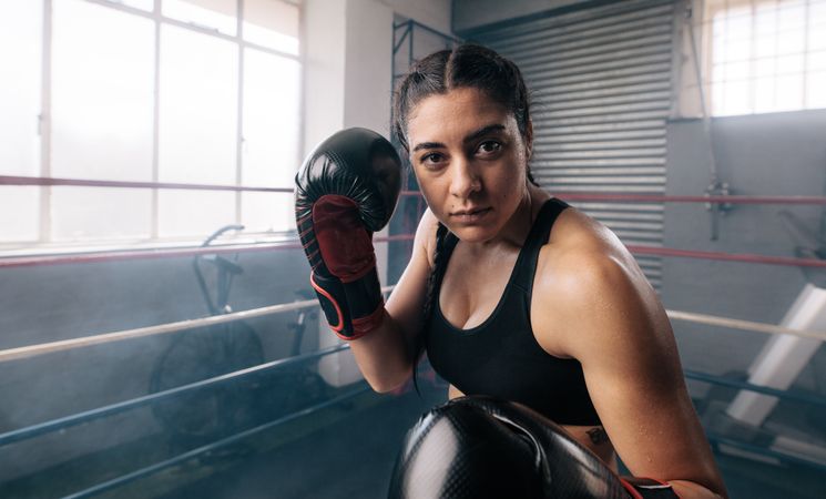 Portrait of female boxer punching inside a boxing ring