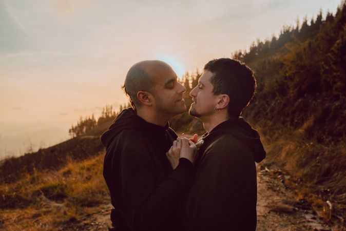 Men hugging and kissing in forest