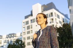 Serious businesswoman leaning on railing