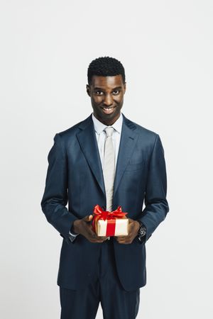 Professional Black man holding a wrapped present