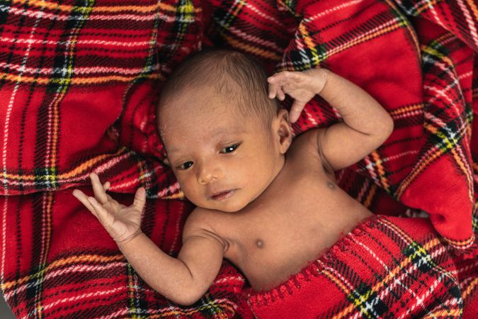 Newborn baby on soft tartan blanket