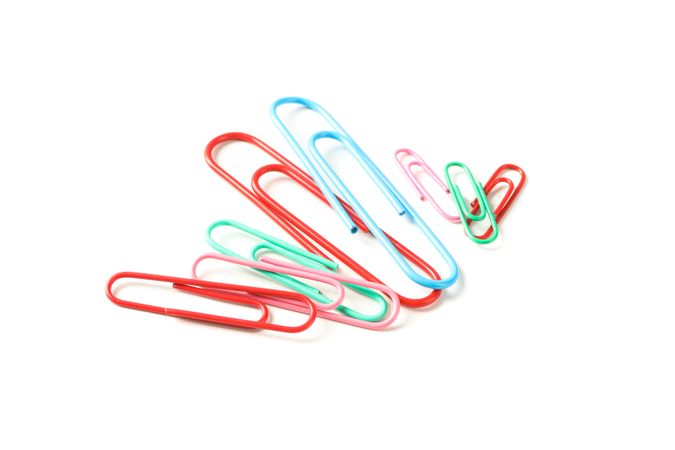 Color paper clips isolated on studio background, closeup