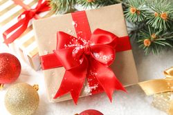 Gift box with bow on decorated background, close up