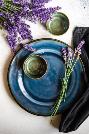Delicate summer table setting with lavender flowers on navy plate