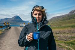 Woman with ceramic mug near rural bridge