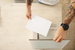 Top view man putting paper in printer