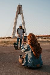 Couple on rural road taking photo with mobile phone