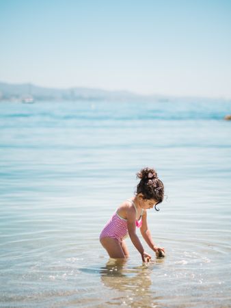 Cute girl playing in water of seaside