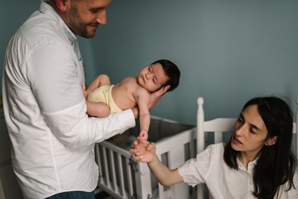 Parents holding baby in room