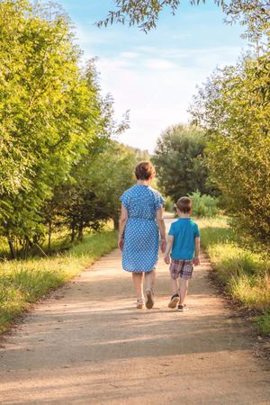 Grandmother and grandchild walking on a path in park