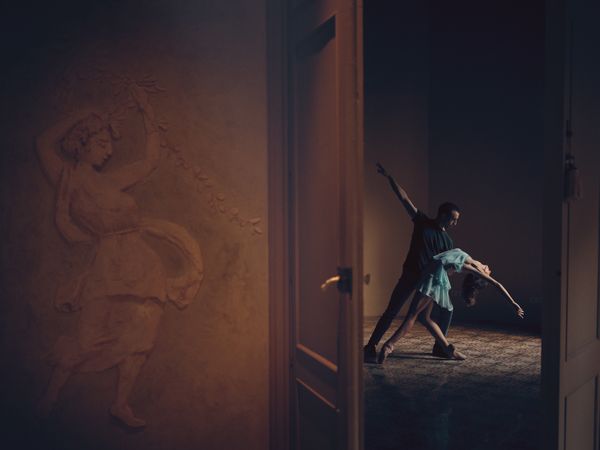 Couple of ballet artists during dance in dark room