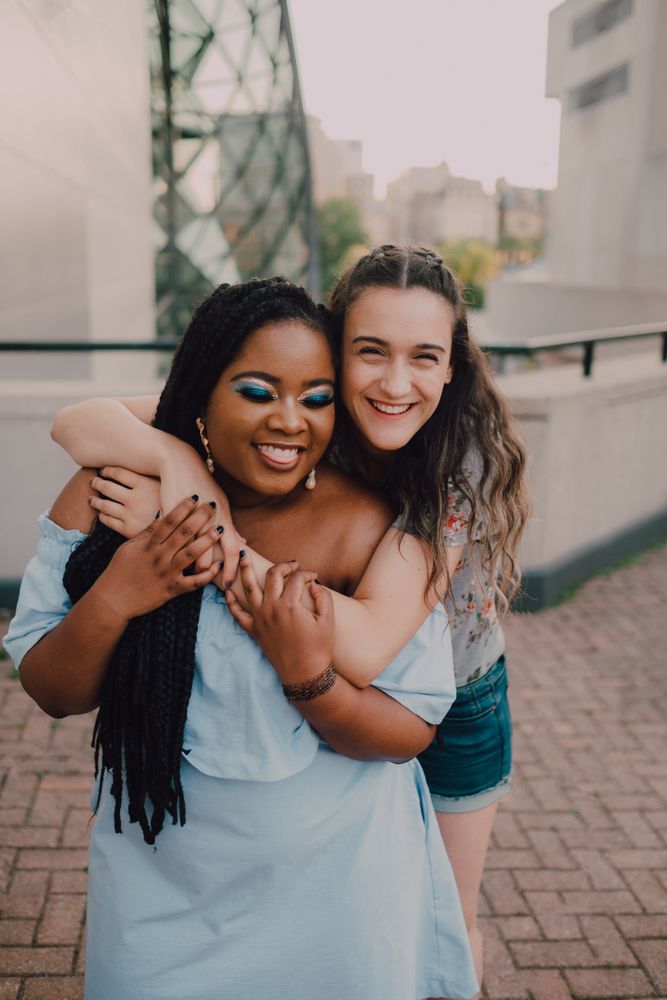 Multiethnic modern women embracing on street