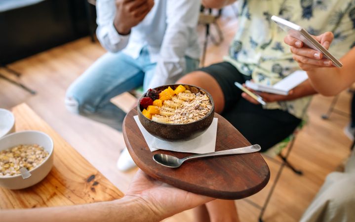 Chef showing vegan bowl to food bloggers and influencers taking pictures in cooking master class