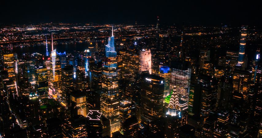 Helicopter Tour of New York City Architecture at Night. Fly-By Over Midtown Manhattan Office Buildings and Skyscrapers Towards Madison Square Garden. Aerial Urban Landscape with Lights in the Evening