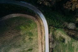 Van riding on countryside road near field