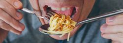 Man eating spaghetti with worms