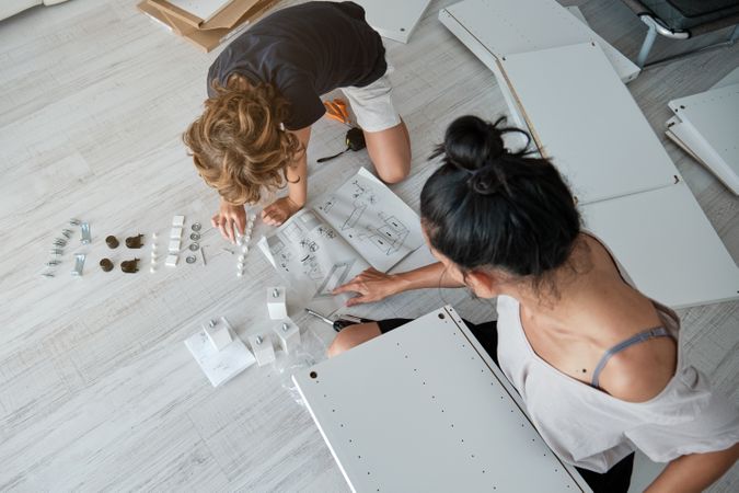 Unrecognizable woman and kid examining blueprint