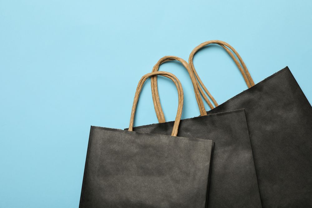 dark paper bags on blue background, space for text