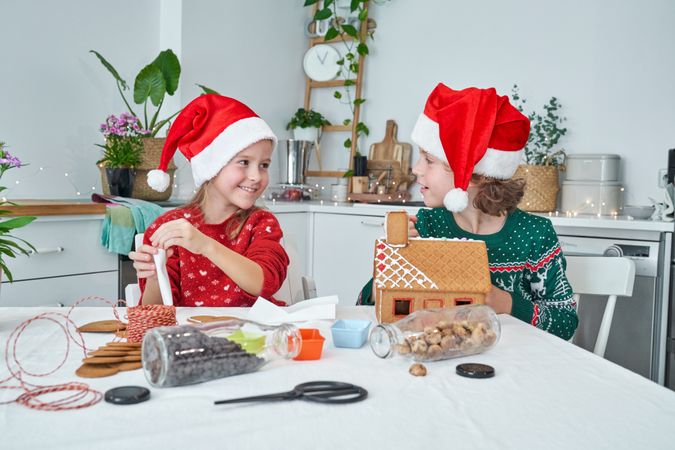 Happy kids making gingerbread house together