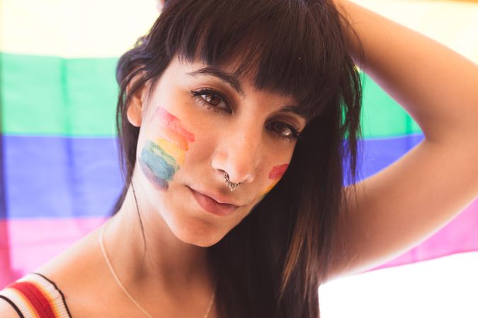Brunette woman with LGBTQIA symbol on face