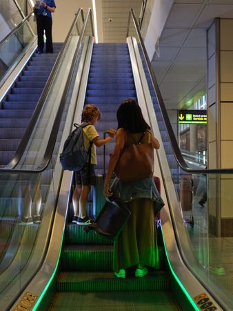 Mother and son on escalator at airport