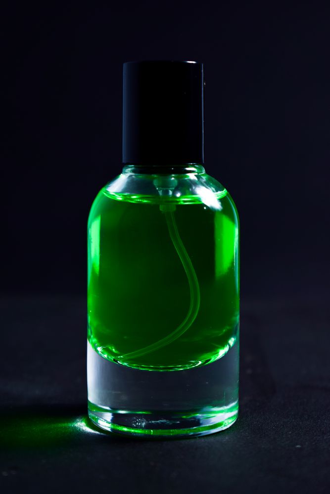 Red perfume bottle in dark studio with space for text