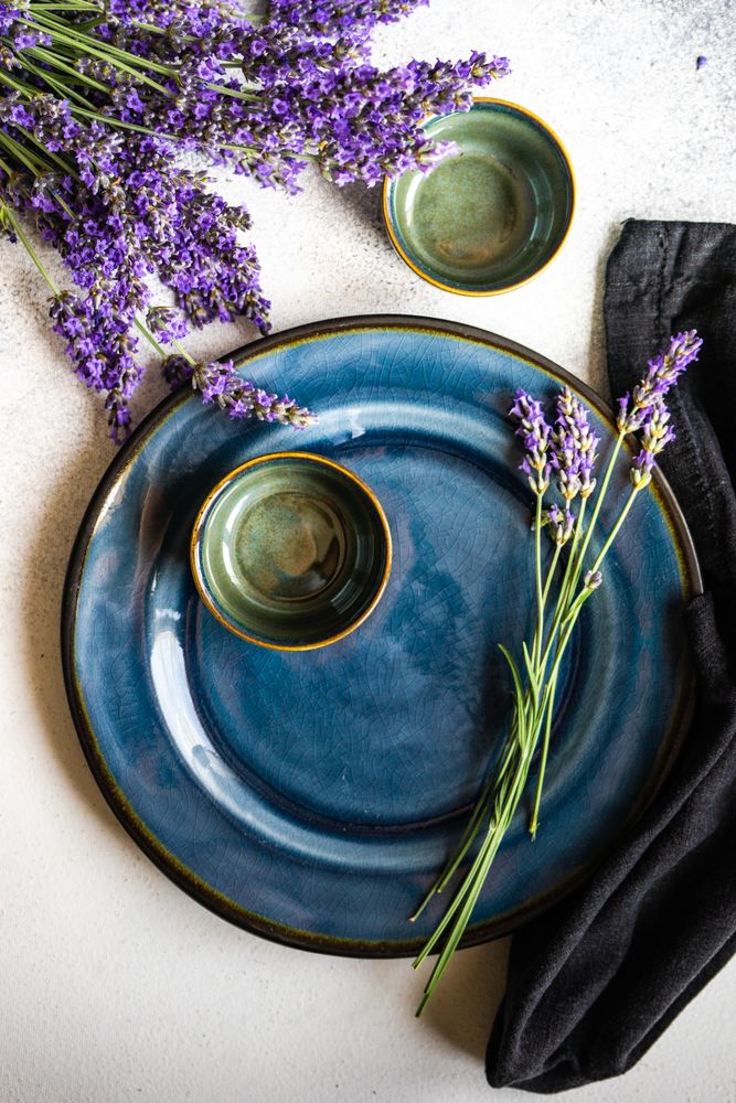 Delicate summer table setting with lavender flowers on navy plate