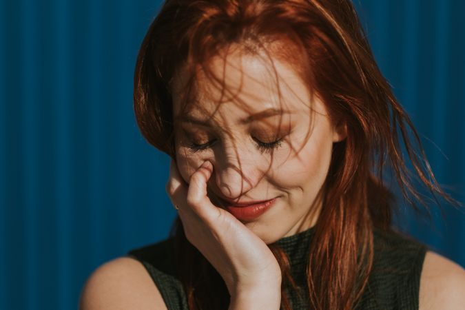 Smiling woman squinting in sun and enjoying weather