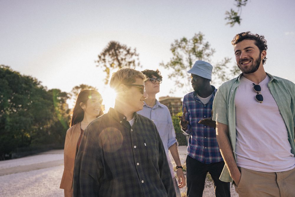 A diverse group of friends enjoy outdoor togetherness, celebrating unity in a vibrant summer.