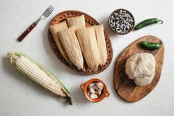 Dough near corn husk and spices for tamales