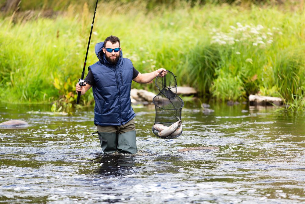 Fisherman crossing river with catch