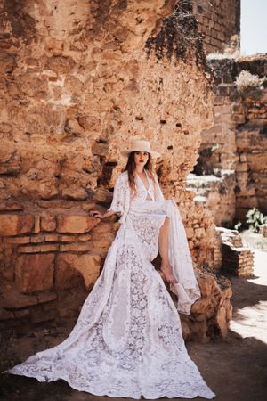 female sitting by ruined wall