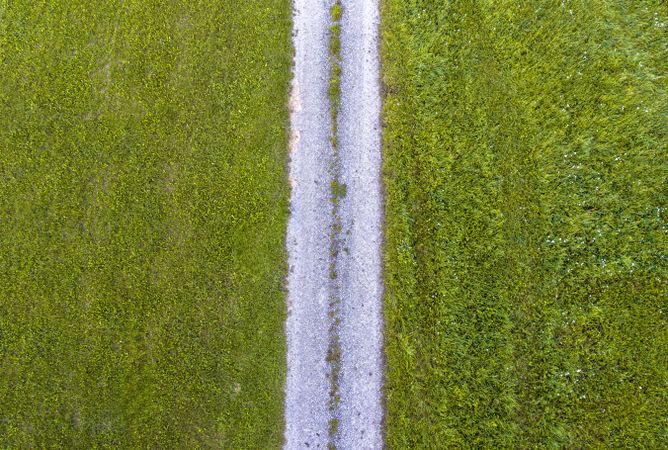 Drone aerial view with green grass fields and countryside road