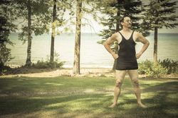 Gentleman Dressed in 1920’s Era Swimsuit Holding Suitcases on Porch