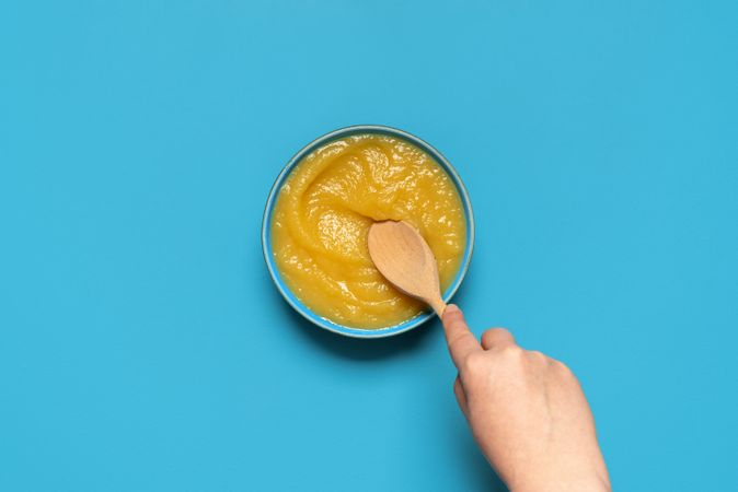 Homemade apple sauce top view on a blue background