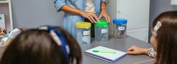 Teacher and students in an ecology classroom learning to recycle by sorting waste