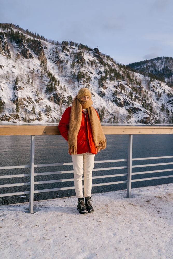 Woman enjoying landscape of river and snowy mountains