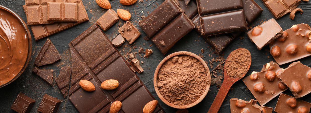 Chocolate, melted chocolate and almond on dark background