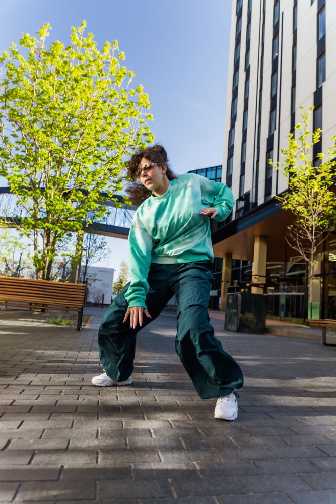 Vertical Screen: Young And Stylish Female Hip-Hop Dancer Freestyling On City Street Among Tall Buildings.