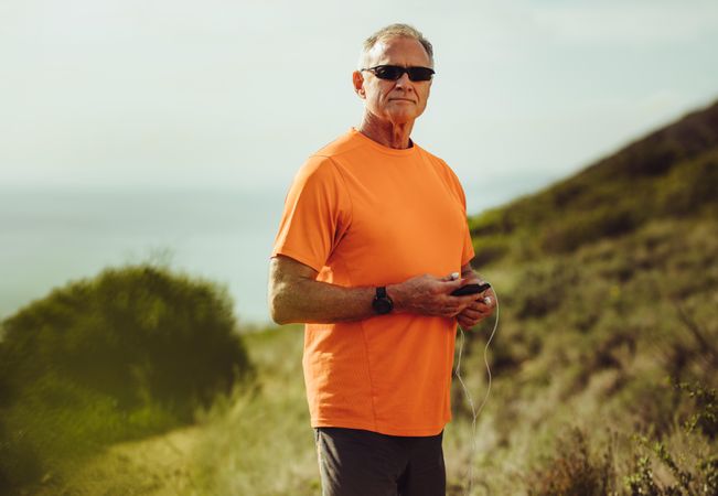 Portrait of a mature man in fitness gear standing on a hill