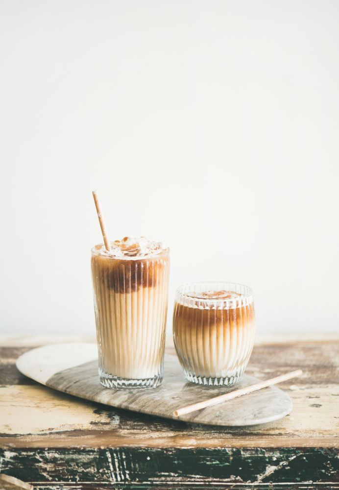 Two cups of iced coffee in clear classes with eco friendly straight on light background