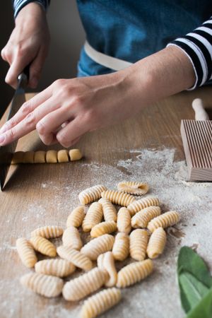 Crop woman making gnocchetti pasta