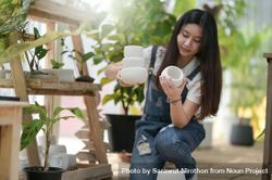 Asian female picking a variety plant pots at work 5w1yLb