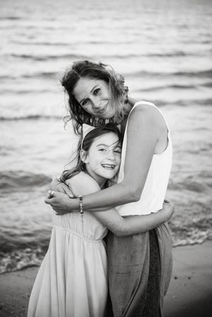 Beautiful mother and daughter embracing on beach