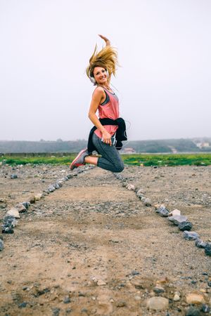 Young sportswoman jumping on the road