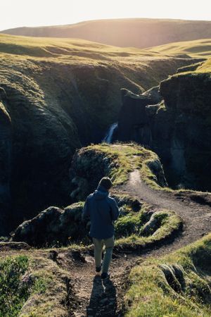 Back of man walking down trail in nature