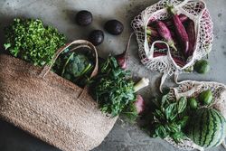 Overhead shot of full grocery shopping jute and mesh bags with fresh produce