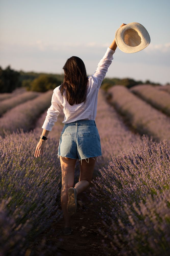 Anonymous woman walking in lavender field