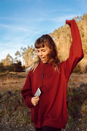 Young woman with smartphone dancing