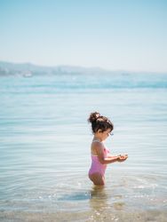 Cute girl playing in water of seaside